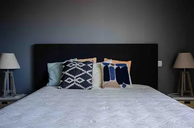 a bedroom with a bed with pillows and two lamps at Casamea - Vue mer, Terrasse, Clim, Proche Plage in Porticcio