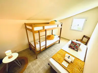 a room with two bunk beds and a table at Appartement front de mer et piscines in Ghisonaccia