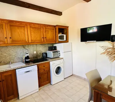 a kitchen with a white refrigerator and a washer and dryer at Appartement front de mer et piscines in Ghisonaccia