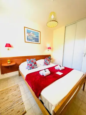a bedroom with a bed with two towels on it at Appartement front de mer et piscines in Ghisonaccia