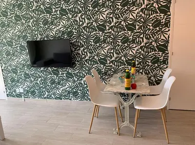 a table and chairs in a room with a wall at bellucciu di porto vecchio***. (Piscine chauffée) in Porto-Vecchio