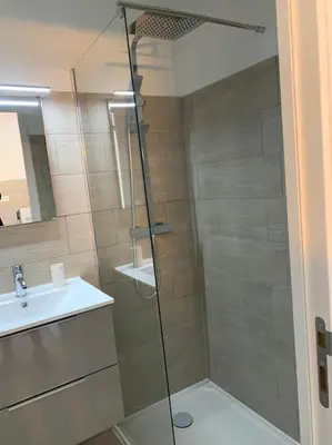 a shower with a glass door next to a sink at bellucciu di porto vecchio***. (Piscine chauffée) in Porto-Vecchio