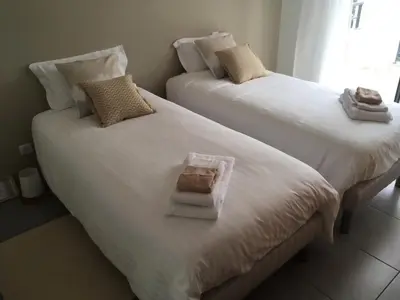two beds with towels and a box on them at Les Terrasses de la Pinède - Appt climatisé in Coti-Chiavari