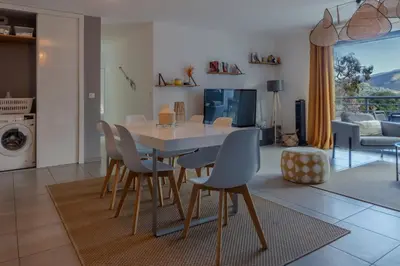a dining room and living room with a table and chairs at Les Terrasses de la Pinède - Appt climatisé in Coti-Chiavari