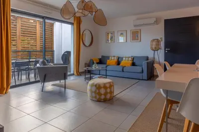 a living room with a blue couch and a table at Les Terrasses de la Pinède - Appt climatisé in Coti-Chiavari