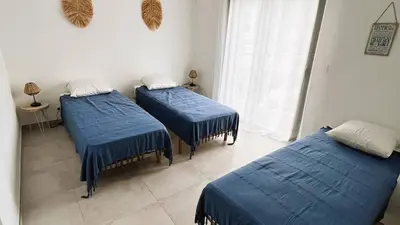 two beds in a room with blue sheets at Villa Copains, 5 pers, piscine chauffée, 5 mn plage in Cirendinu