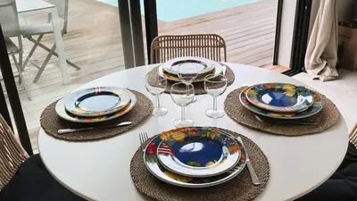 a white table with plates and wine glasses on it at Villa Copains, 5 pers, piscine chauffée, 5 mn plage in Cirendinu