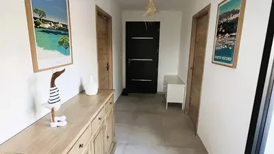 a room with a wooden dresser and a black door at Villa Copains, 5 pers, piscine chauffée, 5 mn plage in Cirendinu