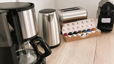 a kitchen counter with a coffee maker and a box of donuts at Villa Copains, 5 pers, piscine chauffée, 5 mn plage in Cirendinu