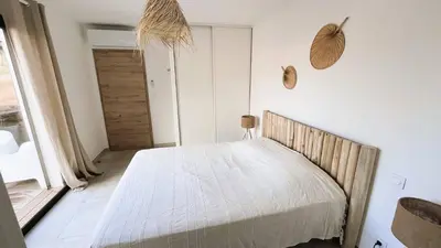 a bedroom with a bed in a room with a door at Villa Copains, 5 pers, piscine chauffée, 5 mn plage in Cirendinu