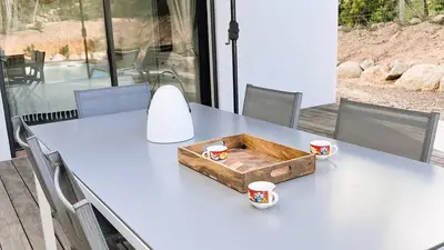 a table with two cups and a box on it at Villa Copains, 5 pers, piscine chauffée, 5 mn plage in Cirendinu
