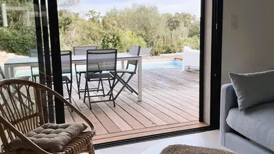 a patio with a table and chairs on a deck at Villa Copines, 4 pers, piscine chauffée, 5 mn plage in Cirendinu