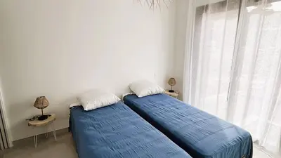 two beds sitting in a room with a window at Villa Copines, 4 pers, piscine chauffée, 5 mn plage in Cirendinu