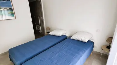 two beds in a room with blue sheets at Villa Copines, 4 pers, piscine chauffée, 5 mn plage in Cirendinu
