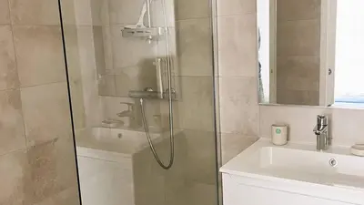 a shower with a glass door next to a sink at Villa Copines, 4 pers, piscine chauffée, 5 mn plage in Cirendinu