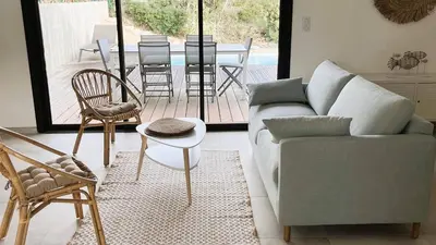 a living room with a couch and chairs and a table at Villa Copines, 4 pers, piscine chauffée, 5 mn plage in Cirendinu