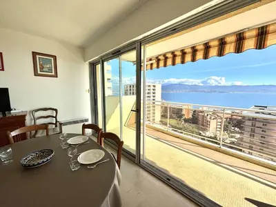 a dining room with a table and a view of the ocean at Appartement L'Aiglon 1 centre-ville Ajaccio in Ajaccio