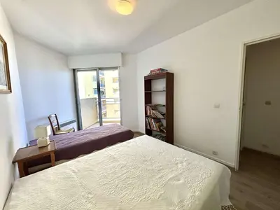 a bedroom with two beds and a book shelf at Appartement L'Aiglon 1 centre-ville Ajaccio in Ajaccio