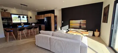 a living room with a couch and a kitchen at Casa di Famiglia - Maison 3 chambres, piscine - Classée 4 étoiles in Figari