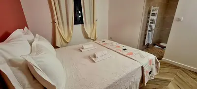 a bedroom with a white bed with pillows on it at Casa di Famiglia - Maison 3 chambres, piscine - Classée 4 étoiles in Figari