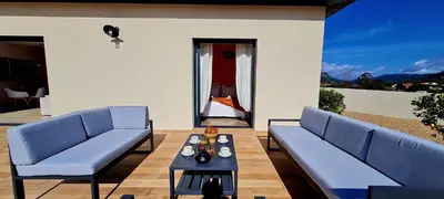 a living room with two blue couches and a table at Casa di Famiglia - Maison 3 chambres, piscine - Classée 4 étoiles in Figari