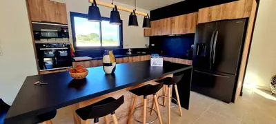 a kitchen with a black counter and a refrigerator at Casa di Famiglia - Maison 3 chambres, piscine - Classée 4 étoiles in Figari