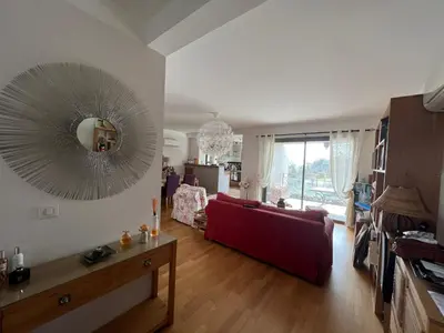 a living room with a red couch and a mirror at APPARTEMENT STANDING AJACCIO 5mn A PIEDS PLAGE DU RICANTO AJACCIO in Ajaccio