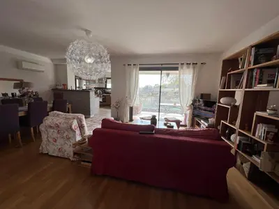 a living room with a red couch and a dining room at APPARTEMENT STANDING AJACCIO 5mn A PIEDS PLAGE DU RICANTO AJACCIO in Ajaccio
