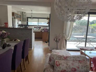 a kitchen and a living room with a table and chairs at APPARTEMENT STANDING AJACCIO 5mn A PIEDS PLAGE DU RICANTO AJACCIO in Ajaccio