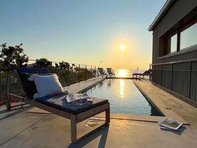 a balcony with a chair next to a swimming pool at Villa San Joseph in Cargèse