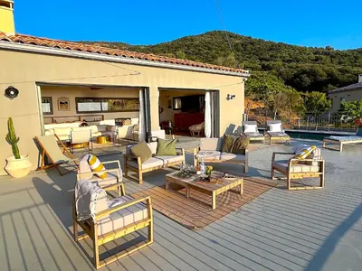 a patio with a bunch of chairs and tables at Villa San Joseph in Cargèse