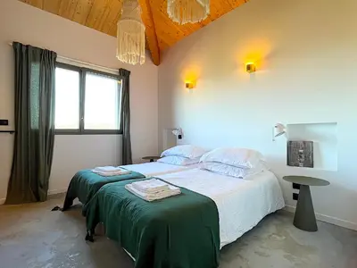 a bedroom with a large bed and a window at Villa San Joseph in Cargèse