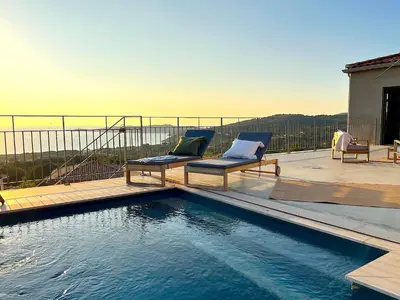 a swimming pool with two chairs sitting on a deck at Villa San Joseph in Cargèse