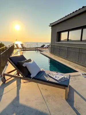 a chaise lounge on a patio next to a swimming pool at Villa San Joseph in Cargèse