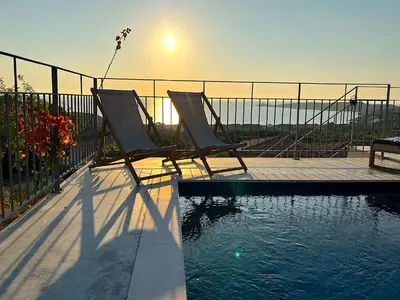 two chairs sitting next to a swimming pool at Villa San Joseph in Cargèse
