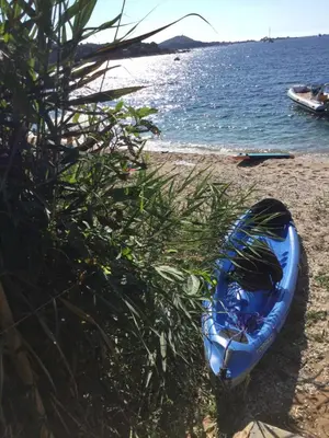 a blue kayak sitting on a beach next to the water at Villa HAPPY DAYS in Pietrosella