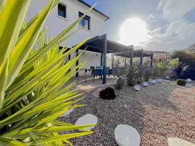 a garden with a picnic table and a building at La Maison de vacances à Ajaccio- Proche plage et aéroport- Extérieur privatif avec barbecue in Ajaccio