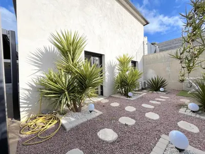 a garden with rocks and plants in front of a building at La Maison de vacances à Ajaccio- Proche plage et aéroport- Extérieur privatif avec barbecue in Ajaccio