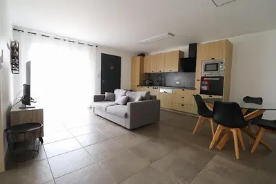a living room with a couch and a table at La Maison de vacances à Ajaccio- Proche plage et aéroport- Extérieur privatif avec barbecue in Ajaccio
