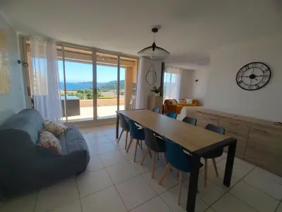 a living room with a table and chairs and a couch at Villa Bell'am Corse in Porto-Vecchio