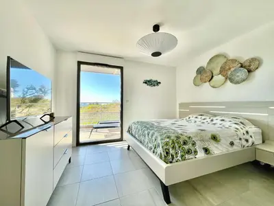 a bedroom with a bed and a television and a window at Appartamentu A Leccia in Grosseto-Prugna