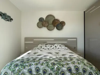 a bedroom with a bed and two plates on the wall at Appartamentu A Leccia in Grosseto-Prugna