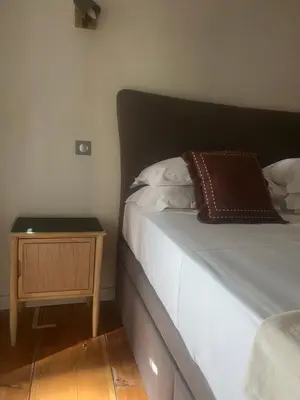 a bedroom with a bed with a nightstand next to it at Appartement prestige, cour Paoli in Corte