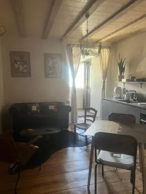 a living room with a table and chairs and a kitchen at Appartement prestige, cour Paoli in Corte