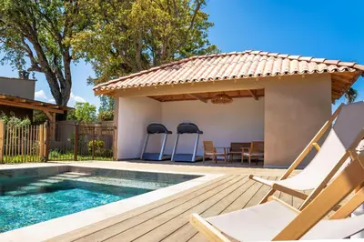 a pool with a deck and chairs next to a house at Casamea - T3 U Benestà in Talasani