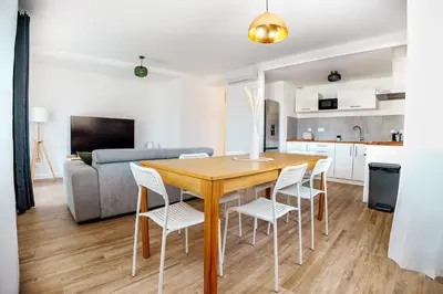 a kitchen and living room with a wooden table and chairs at Casamea - T3 U Benestà in Talasani