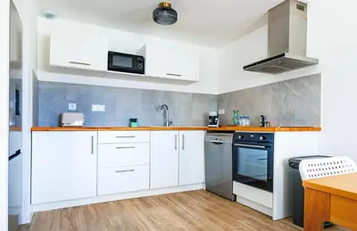 a kitchen with white cabinets and a sink at Casamea - T3 U Benestà in Talasani