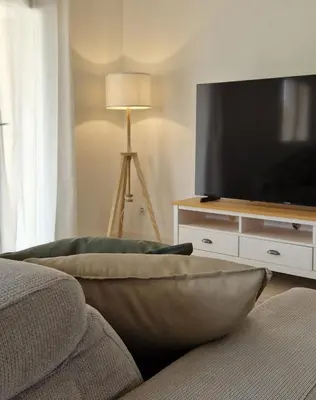 a living room with a couch and a flat screen tv at Casamea - T3 U Benestà in Talasani