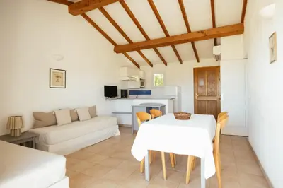 a living room with a white table and a couch at Les Hauts de Santa Giulia in Porto-Vecchio