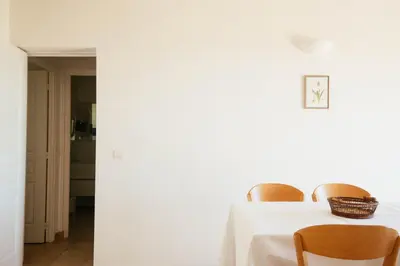 a dining room with a white table and chairs at Les Hauts de Santa Giulia in Porto-Vecchio